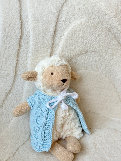 Close-up of Jellycat Lollie Lamb plush in a soft blue hand-knitted vest, showcasing the stitch pattern and fit.