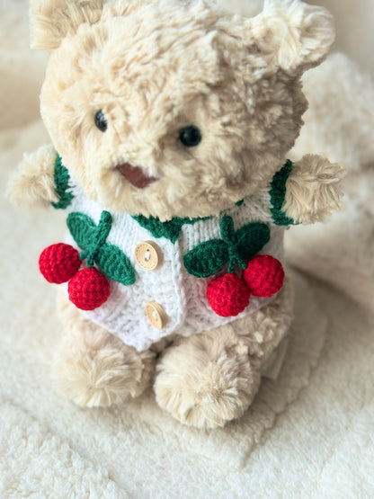 Top view of Jellycat Bart Junior in a handmade cherry-themed crochet cardigan, designed as a plush accessory for Bartholomew Bear Junior.
