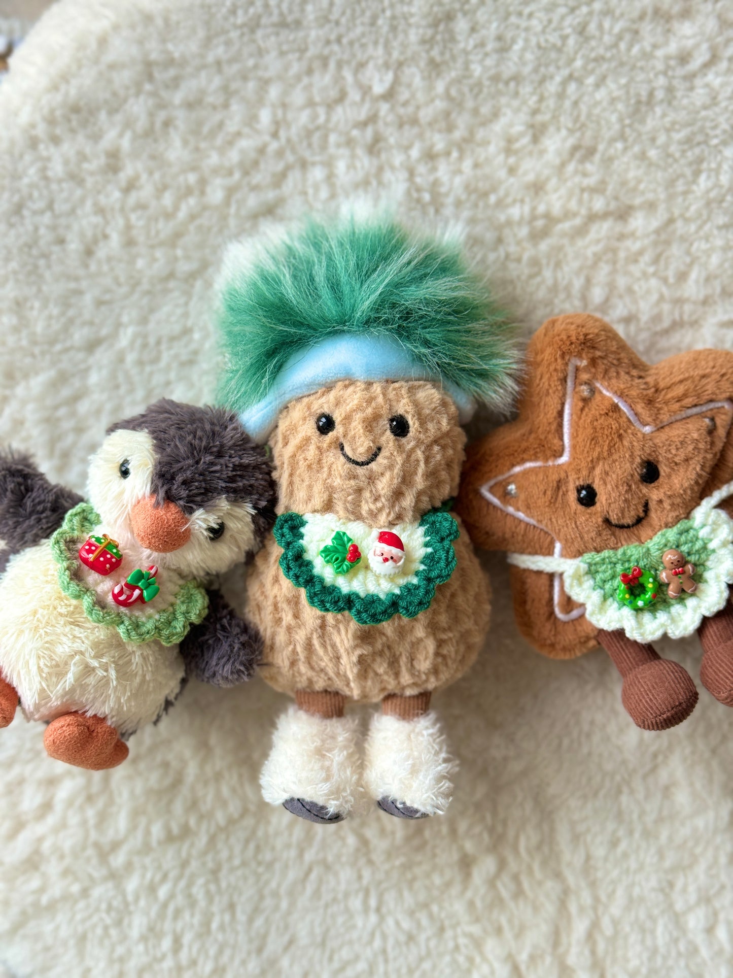 Three plush toys wearing mini Christmas crochet bib collars