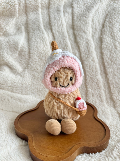 Jellycat Peanut plush wearing a handmade pink crochet ice cream hat and holding a mini crochet cone bag, front view.