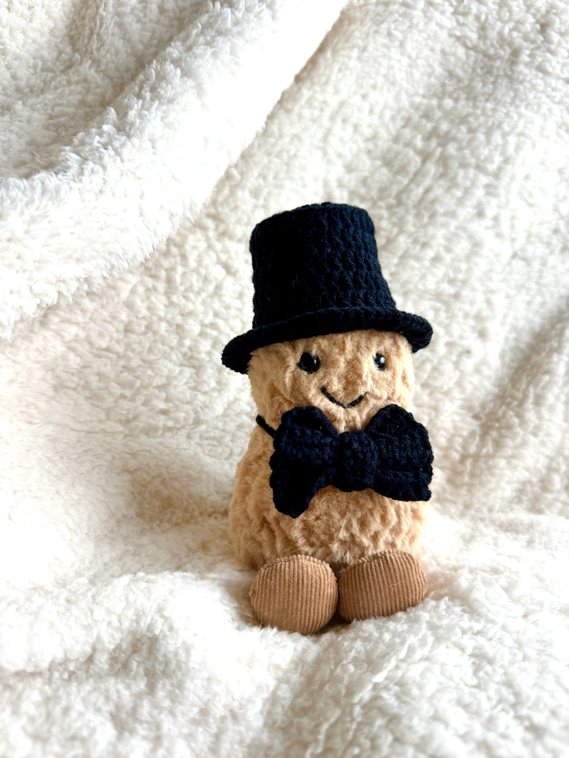 Jellycat Amuseable Peanut wearing a handmade crochet black magician top hat and bow tie.