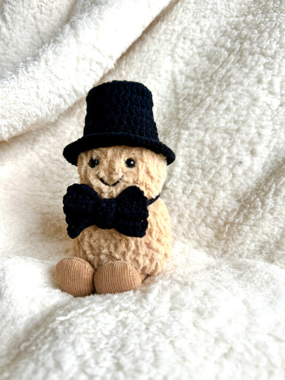 Jellycat Peanut styled in a crochet formal outfit with top hat and bow tie.