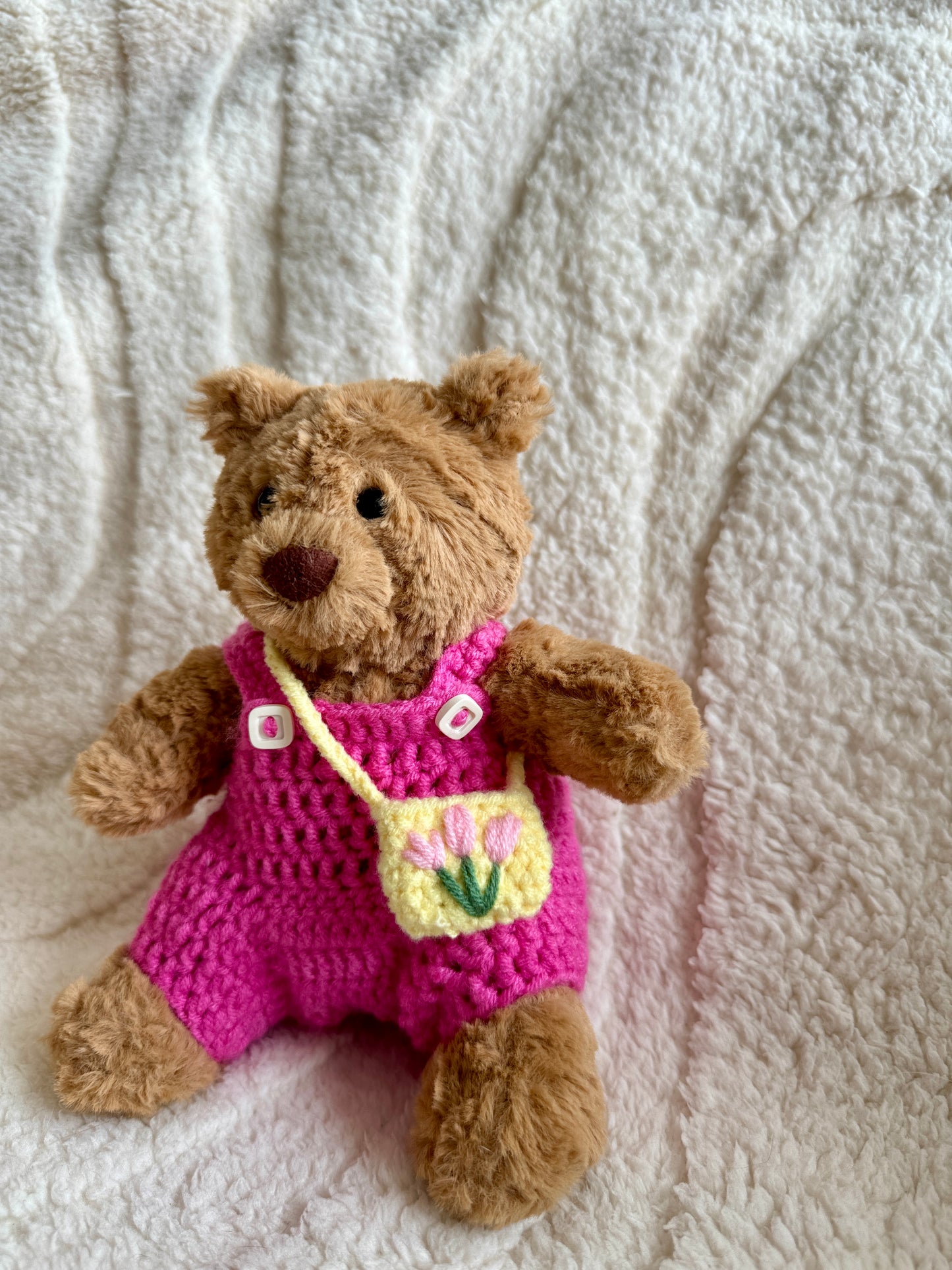 Side angle of the pink romper and tulip bag outfit on the plush bear.

