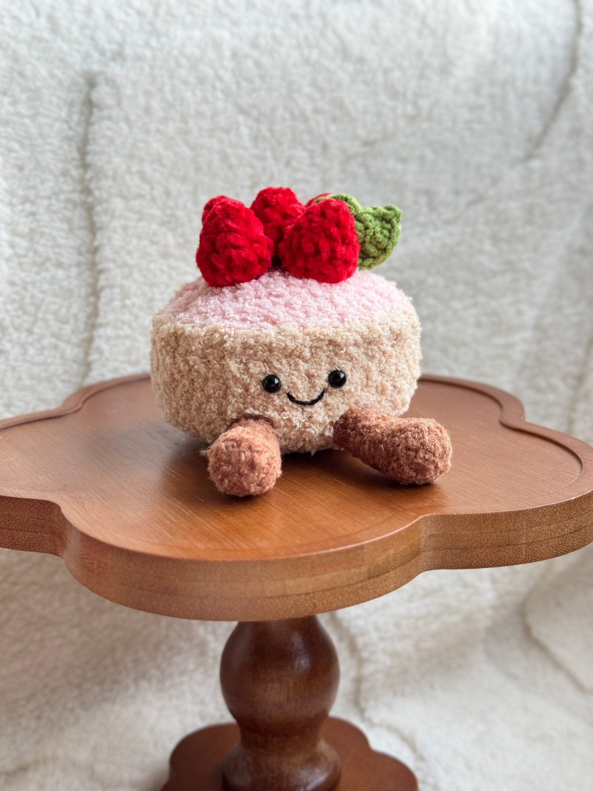 Front view of smiling crochet strawberry tart plush inspired by Jellycat Amuseables.