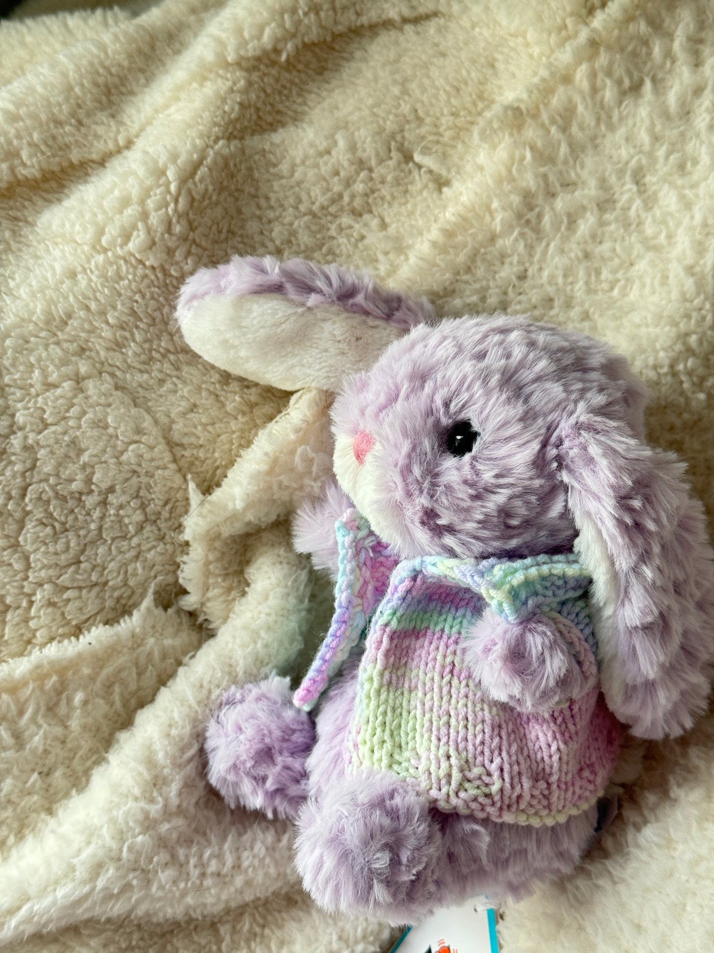 Jellycat Little Bunny 18 cm showing side and back of handmade pastel knit vest on fleece.