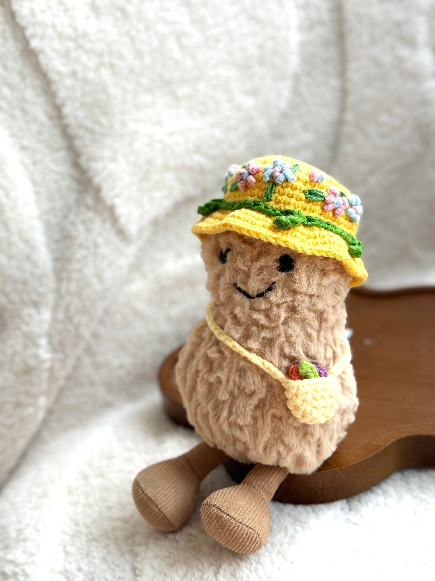 Plush toy wearing a pastel floral embroidered bucket hat and tiny crochet pouch, styled for a spring day look.