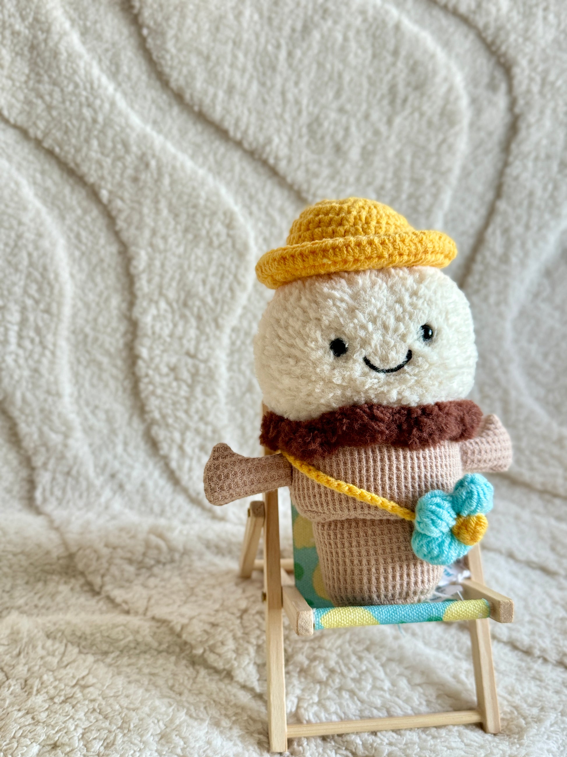 Side view of plush on deck chair showing bag strap and hat brim.