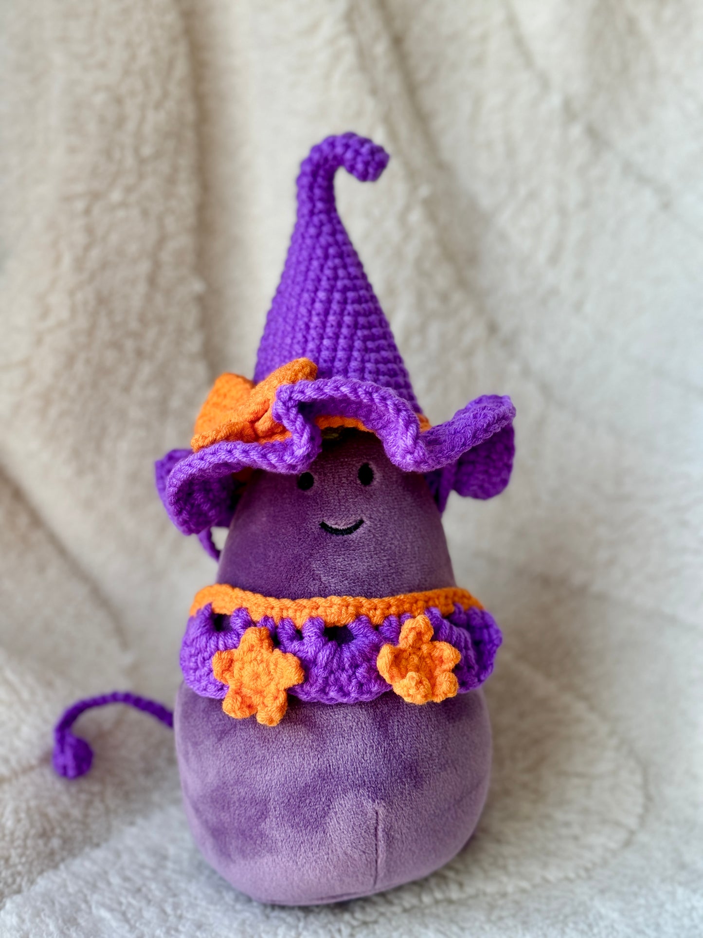 Jellycat Amuseable aubergine styled with violet witch hat and pumpkin-orange star collar.