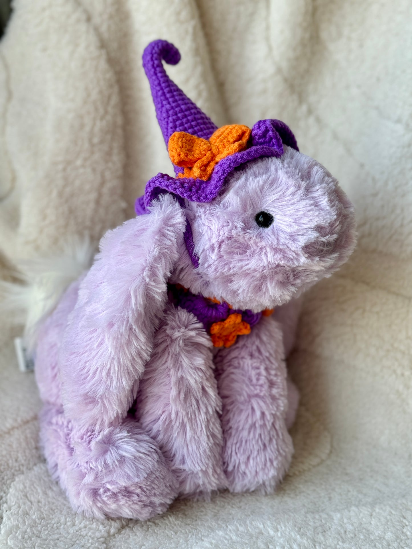 Lilac Jellycat bunny side view showing curly tip witch hat and crocheted star collar.