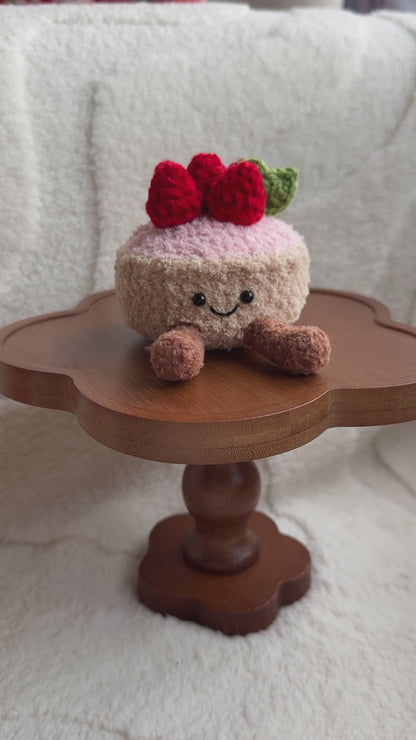 Front view of smiling crochet strawberry tart plush inspired by Jellycat Amuseables.